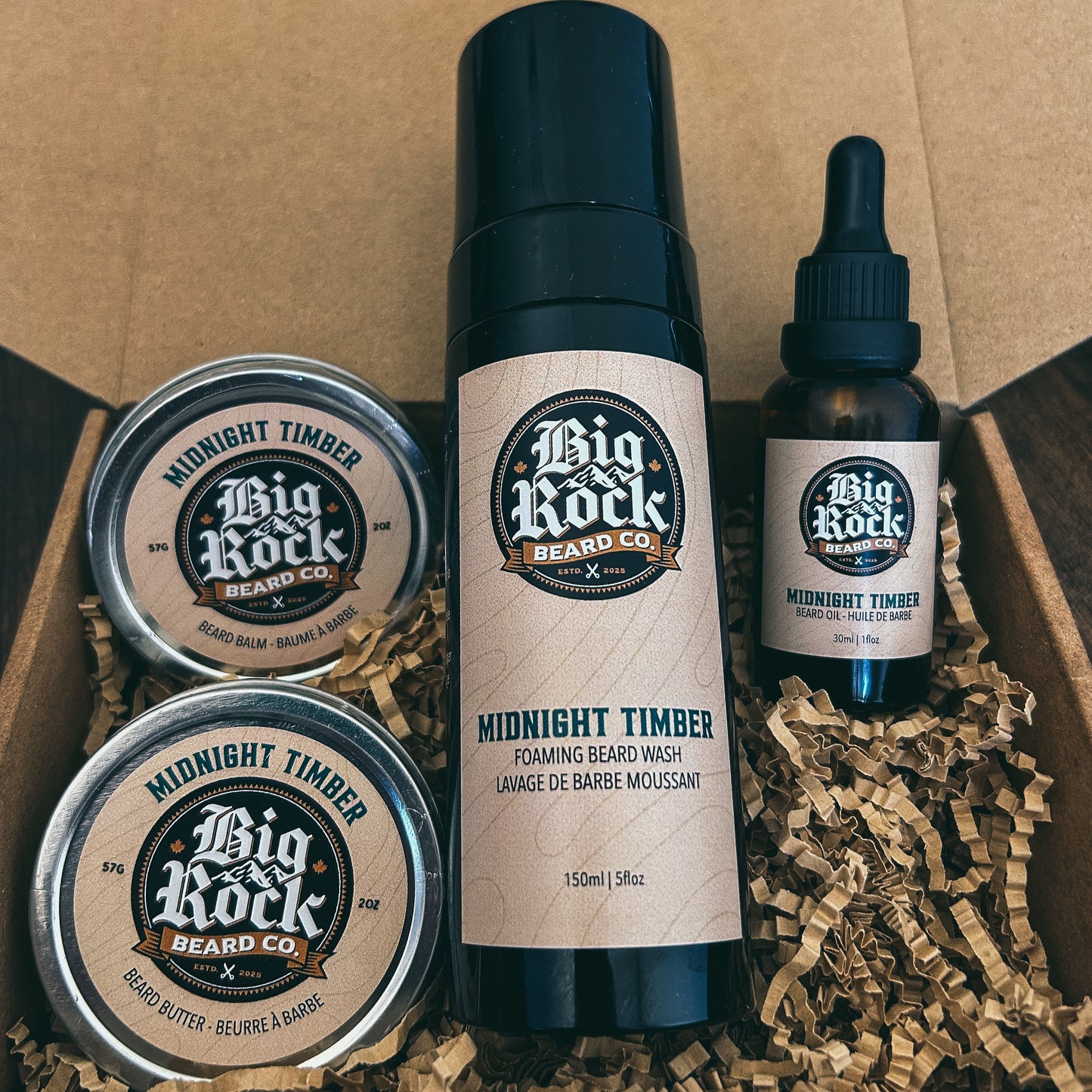 Big Rock Beard Co. grooming products including a bottle, two tins, and a dropper in a cardboard box.